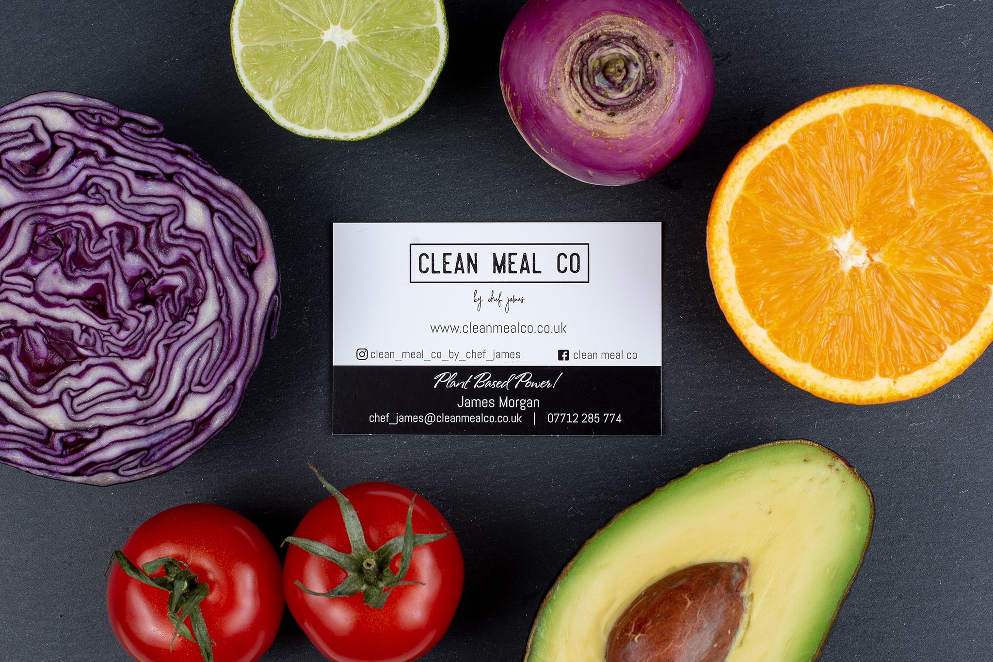Clean Meal Company branded business card, surrounded by fruit and salad on slate tile professionally by Emma Seaney commercial photographer